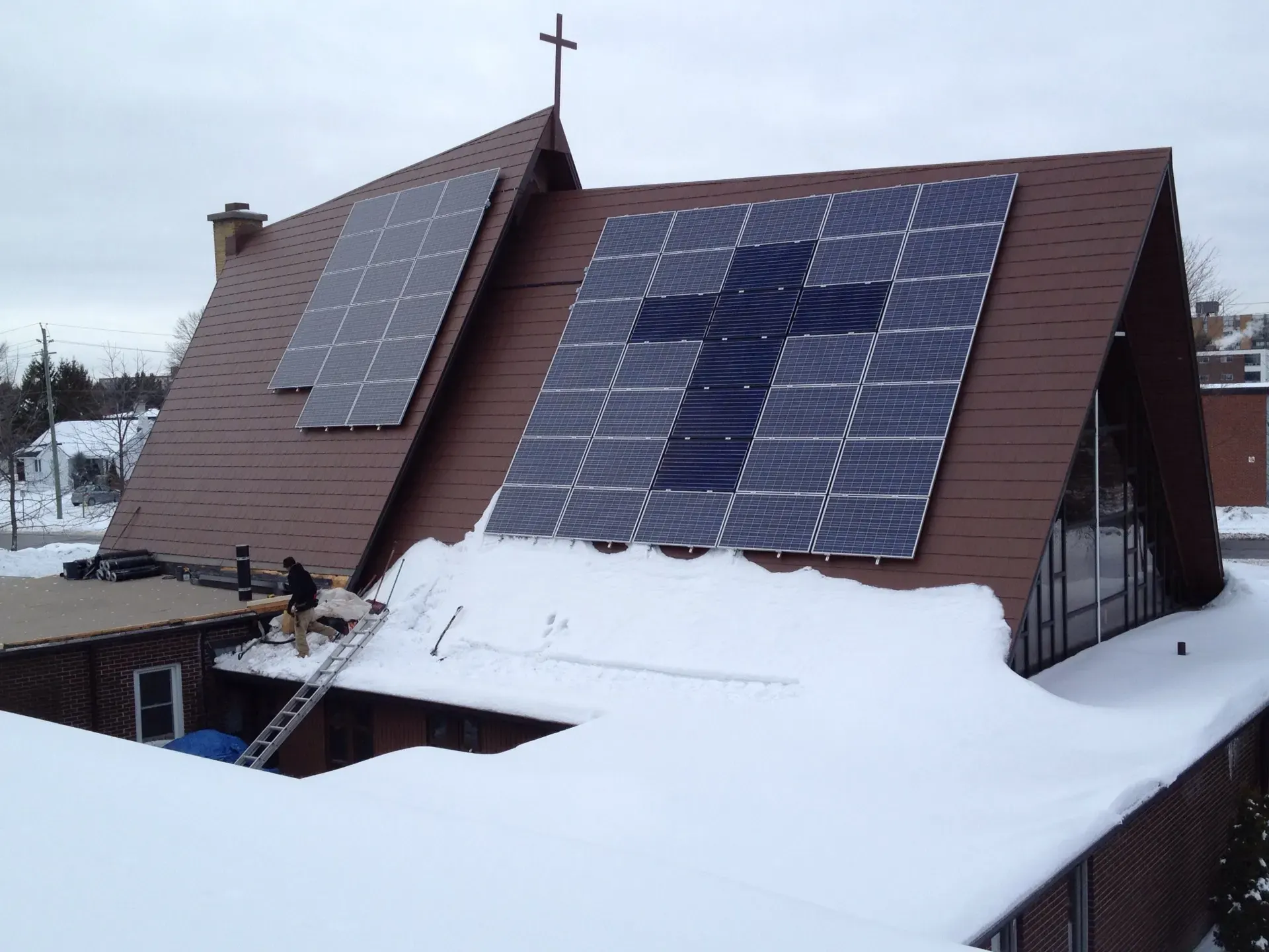 A rooftop solar array installed on a steep church roof in winter