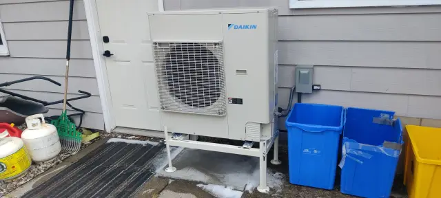 A Denoco outdoor HVAC or heat pump unit on a job site