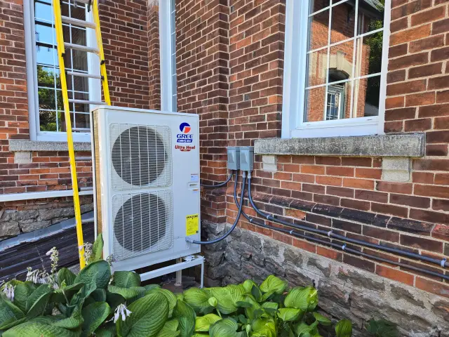 A Denoco outdoor HVAC or heat pump unit on a job site