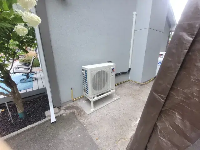 A Denoco outdoor HVAC or heat pump unit on a job site