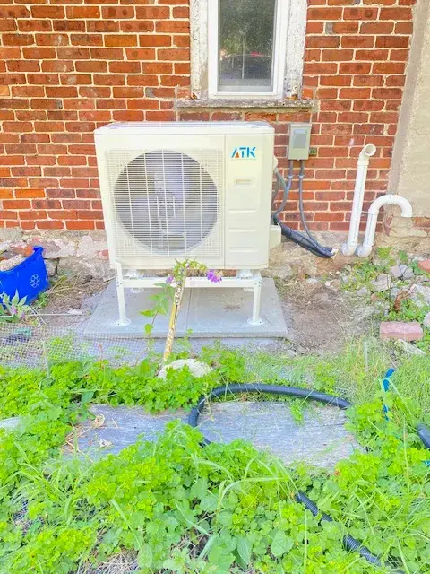 A Denoco outdoor HVAC or heat pump unit on a job site