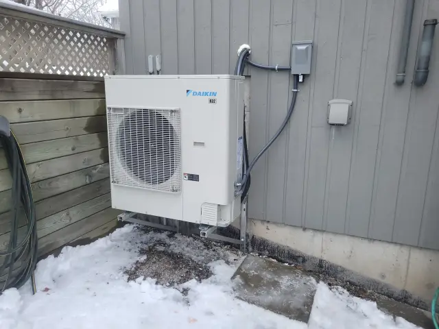 A Denoco outdoor HVAC or heat pump unit on a job site