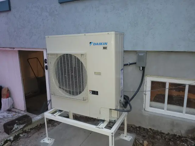 A Denoco outdoor HVAC or heat pump unit on a job site