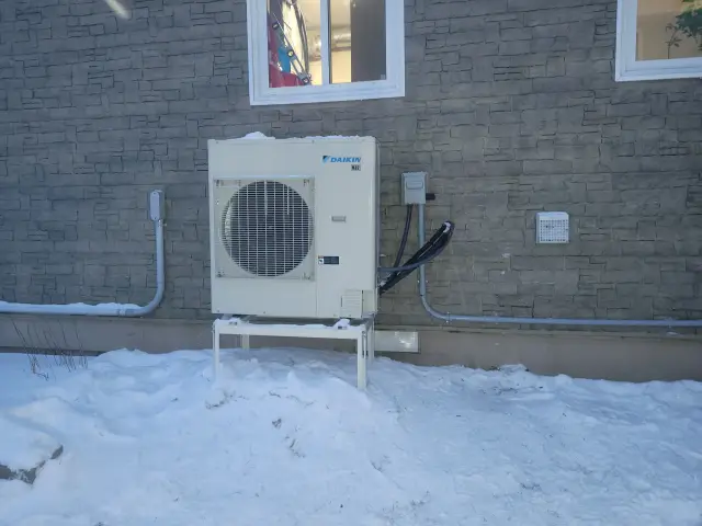 A Denoco outdoor HVAC or heat pump unit on a job site